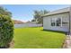 Large backyard features a manicured lawn, a fence, and lush greenery at 5119 Whispering Leaf Trail, Valrico, FL 33596