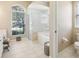 A bright bathroom features a glass shower, large soaking tub, natural light, and neutral colored paint at 5119 Whispering Leaf Trail, Valrico, FL 33596