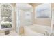 Bright bathroom featuring a glass-enclosed shower and separate tub, with natural light streaming through large windows at 5119 Whispering Leaf Trail, Valrico, FL 33596