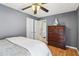 Calm bedroom with a ceiling fan, closet, hardwood floors, and decorative shelving at 5119 Whispering Leaf Trail, Valrico, FL 33596