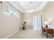 Neutral bedroom with tray ceiling, ceiling fan, workout bike, and study desk illuminated with window light at 5119 Whispering Leaf Trail, Valrico, FL 33596