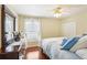 Light-filled bedroom with wood floors, ceiling fan, dresser, and window perfect for relaxation and rest at 5119 Whispering Leaf Trail, Valrico, FL 33596