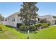 Well-maintained home exterior with lush landscaping, mature trees, and a green lawn at 5119 Whispering Leaf Trail, Valrico, FL 33596
