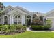 Attractive home featuring manicured landscaping, arched windows, and a welcoming entrance at 5119 Whispering Leaf Trail, Valrico, FL 33596