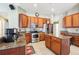 Kitchen featuring stainless steel appliances, an island with granite countertop, and wood cabinets at 5119 Whispering Leaf Trail, Valrico, FL 33596