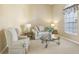 A cozy living room features a plush sofa, armchair, glass coffee table, and lots of natural light at 5119 Whispering Leaf Trail, Valrico, FL 33596