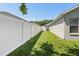Yard view along the side of the home with a white privacy fence and green grass at 5119 Whispering Leaf Trail, Valrico, FL 33596