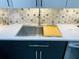 Modern kitchen sink with stainless steel fixtures, a white countertop, and a decorative backsplash at 5200 Brittany S Dr # 204, St Petersburg, FL 33715