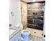 Bathroom featuring a glass enclosed shower with wood-look tile, stone countertop vanity, and updated fixtures at 5340 Royal Palm Ave # 5340, Sarasota, FL 34234