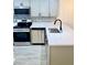 Contemporary kitchen with stainless appliances, white cabinets, gray backsplash, and stone countertops at 5340 Royal Palm Ave # 5340, Sarasota, FL 34234