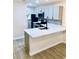 Well-lit kitchen showcases white cabinets, stone countertops, stainless steel appliances, and sleek gray backsplash at 5340 Royal Palm Ave # 5340, Sarasota, FL 34234