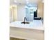 Modern kitchen featuring stone countertops, stainless steel sink, and a black faucet set against a backdrop of white cabinetry at 5340 Royal Palm Ave # 5340, Sarasota, FL 34234