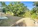 Large backyard with mature trees, partial fence, and lawn at 5410 Treig Ln, Wesley Chapel, FL 33545