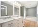 Bright bathroom features dual sinks, tub, and neutral paint at 5410 Treig Ln, Wesley Chapel, FL 33545