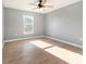 Bedroom with ceiling fan, window, and light wood flooring at 5410 Treig Ln, Wesley Chapel, FL 33545
