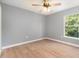 Bedroom showcasing ceiling fan, light wood floors, and window at 5410 Treig Ln, Wesley Chapel, FL 33545
