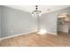 Bright dining room featuring an elegant light fixture and wood-look flooring at 5410 Treig Ln, Wesley Chapel, FL 33545