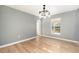 Bright dining room featuring an elegant light fixture and wood-look flooring at 5410 Treig Ln, Wesley Chapel, FL 33545