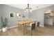 Dining room setup with a wooden table, chairs, and leafy green artwork at 5410 Treig Ln, Wesley Chapel, FL 33545
