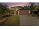 Two-story home with an attached two car garage, mature palm trees, and a well-manicured lawn at 5410 Treig Ln, Wesley Chapel, FL 33545