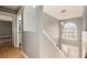 Hallway with stairs, wood floors, a modern chandelier, and natural light at 5410 Treig Ln, Wesley Chapel, FL 33545