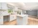 Bright kitchen featuring white cabinets, marble backsplash, a center island, and stainless appliances at 5410 Treig Ln, Wesley Chapel, FL 33545