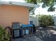 Outdoor grill and utility area with a nearby view of a well-maintained yard and shade tree at 5413 S Martin Ave, Tampa, FL 33611