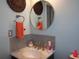 Stylish half bathroom featuring a marble countertop, decorative mirror, and mosaic backsplash at 5413 S Martin Ave, Tampa, FL 33611