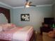 Comfortable bedroom with a ceiling fan, television and artistic details at 5413 S Martin Ave, Tampa, FL 33611