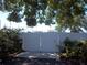 White vinyl privacy fence with double gate and concrete pad, surrounded by greenery and mature trees at 5413 S Martin Ave, Tampa, FL 33611