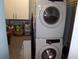 Laundry room with stacked washer and dryer, storage cabinets, and laundry organization at 5413 S Martin Ave, Tampa, FL 33611