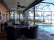 Relaxing screened-in lanai seating area featuring a ceiling fan, wicker chairs, and a view of the sparkling pool at 5413 S Martin Ave, Tampa, FL 33611