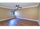 Simple bedroom with wood floors, crown molding, ceiling fan, and a single window overlooking the greenery at 5449 Manatee Point Dr, New Port Richey, FL 34652