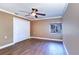 Bedroom featuring wood floors, a ceiling fan, a window, and a built-in closet for ample storage space at 5449 Manatee Point Dr, New Port Richey, FL 34652