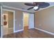 Bedroom with wooden floors, ceiling fan, closet, and doorways to a kitchen and another room at 5449 Manatee Point Dr, New Port Richey, FL 34652