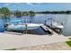 Boat lift on a sunny day with boats docked on a serene waterway, lush greenery and clear skies at 5449 Manatee Point Dr, New Port Richey, FL 34652