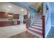 Inviting entryway showcasing a staircase and kitchen with wooden cabinets, granite countertops, and stainless appliances at 5449 Manatee Point Dr, New Port Richey, FL 34652