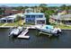 Waterfront home featuring a private dock, two boat lifts, and beautiful blue siding with a matching metal roof at 5449 Manatee Point Dr, New Port Richey, FL 34652