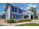 Charming two-story home featuring a second-story balcony, blue trim and lush landscaping at 5449 Manatee Point Dr, New Port Richey, FL 34652