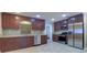 Spacious kitchen featuring rich wood cabinets, stainless steel appliances, granite countertops, and tile flooring at 5449 Manatee Point Dr, New Port Richey, FL 34652