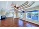 Spacious living room with tray ceiling, a fireplace, wood floors, and large windows providing scenic water views at 5449 Manatee Point Dr, New Port Richey, FL 34652