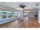 Inviting living room featuring beautiful wood floors, a ceiling fan, and large windows with water views at 5449 Manatee Point Dr, New Port Richey, FL 34652