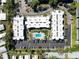 A high-angle view shows a swimming pool, trees and well-maintained complex featuring parking and landscaping at 5509 Fountain Lake Cir # C209, Bradenton, FL 34207