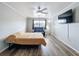 Bedroom with wood floors, large tv, ceiling fan and natural light perfect for relaxation and comfort at 5509 Fountain Lake Cir # C209, Bradenton, FL 34207