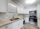 Updated kitchen with stainless steel appliances, stone countertops, and a washer/dryer combo at 5509 Fountain Lake Cir # C209, Bradenton, FL 34207
