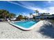 Rectangular community pool surrounded by lounge chairs, palm trees, and a paved deck at 5509 Fountain Lake Cir # C209, Bradenton, FL 34207