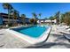 Community pool with lounge chairs and palm trees at 5509 Fountain Lake Cir # C209, Bradenton, FL 34207