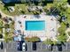 Aerial view shows the rectangle swimming pool, lounge chairs, and tables surrounded by parking and greenery at 5509 Fountain Lake Cir # C209, Bradenton, FL 34207