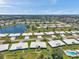 Wide aerial view showcasing the community with white-roofed homes and a serene lake at 6524 11Th W Ave # 5611, Bradenton, FL 34209