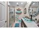 Stylish bathroom featuring a glass vessel sink, decorative mirror, and a walk-in shower with glass door at 6524 11Th W Ave # 5611, Bradenton, FL 34209